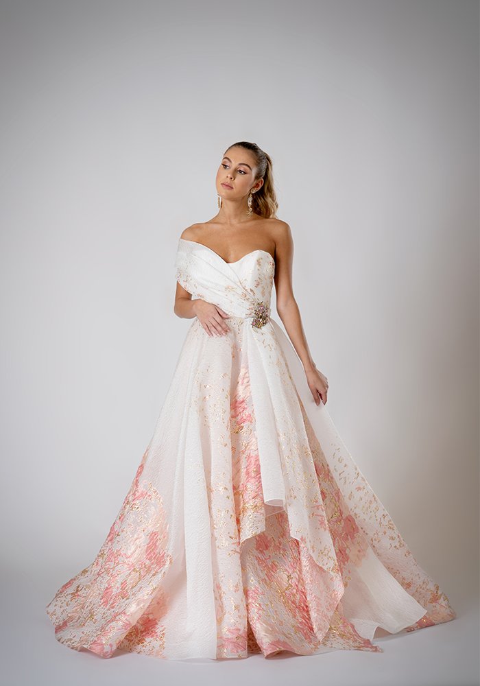 Blush floral jacquard organza strapless A-line evening gown with a sculpted neckline, one-shoulder drape, and Swarovski crystal brooch in Toronto.