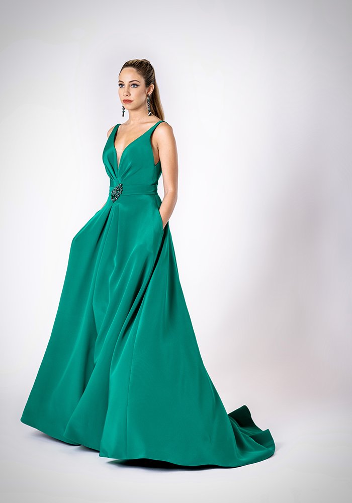 Emerald silk crepe A-line evening gown with front draping, deep V-neckline, slit, pockets, and crystal brooch belt in Toronto.