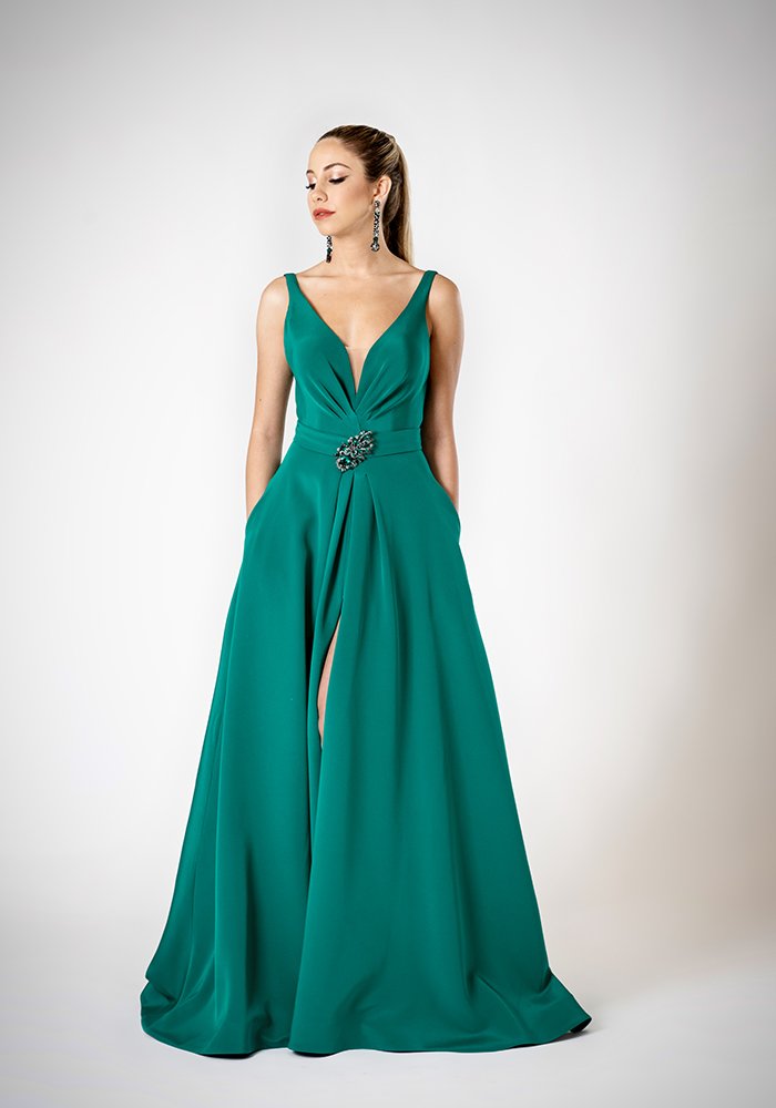 Emerald silk crepe A-line evening gown with front draping, deep V-neckline, slit, pockets, and crystal brooch belt in Toronto.