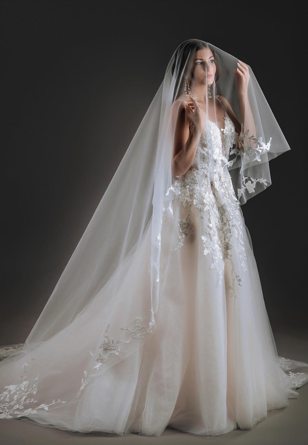 Laura A-line bridal gown in tulle with deep V-neckline, silk organza corset, floral lace, and dimensional beaded appliqués.