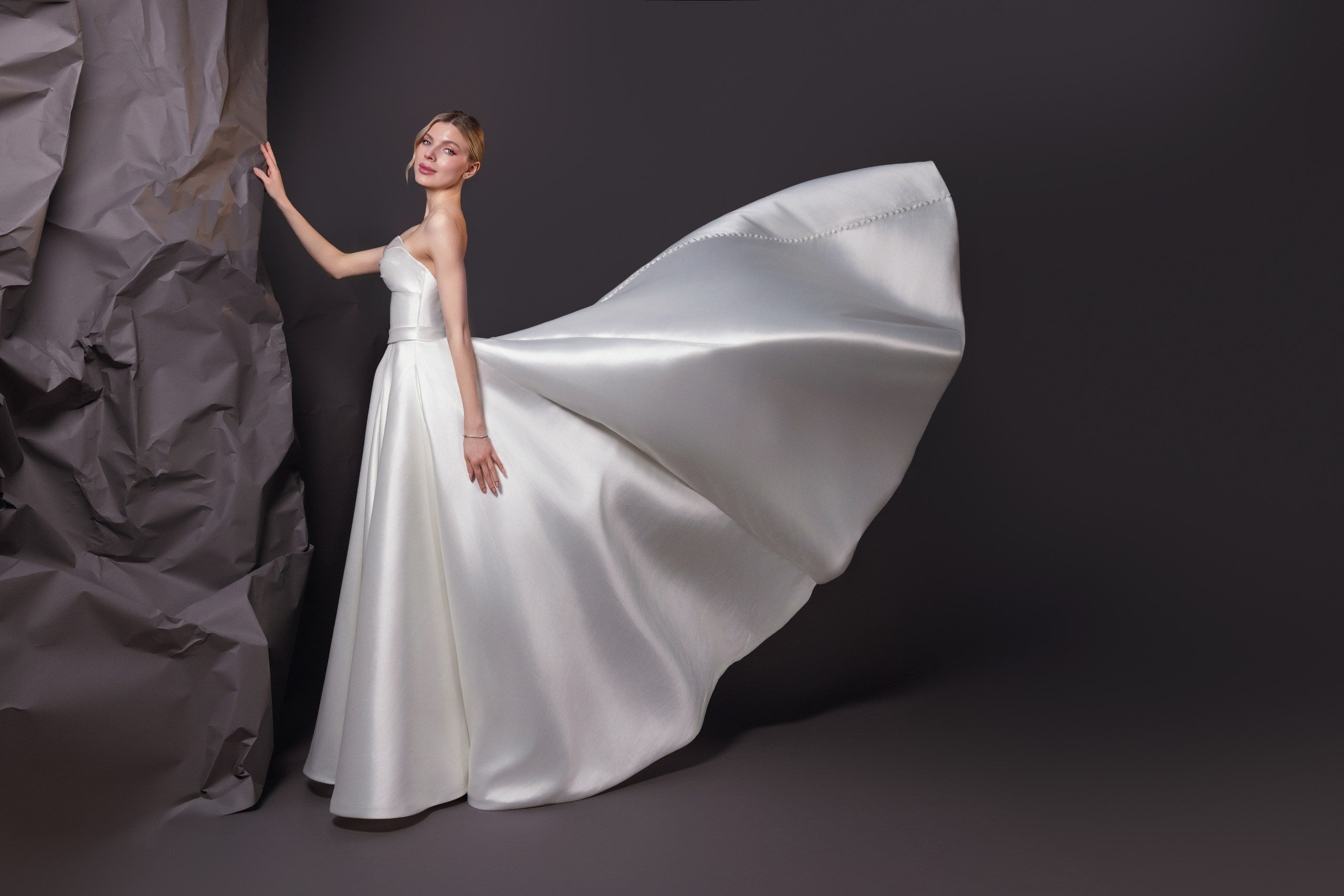Mirabel silk blend Mikado ball gown with a Basque waistline, bow draped bodice, and full skirt with pockets, Toronto.