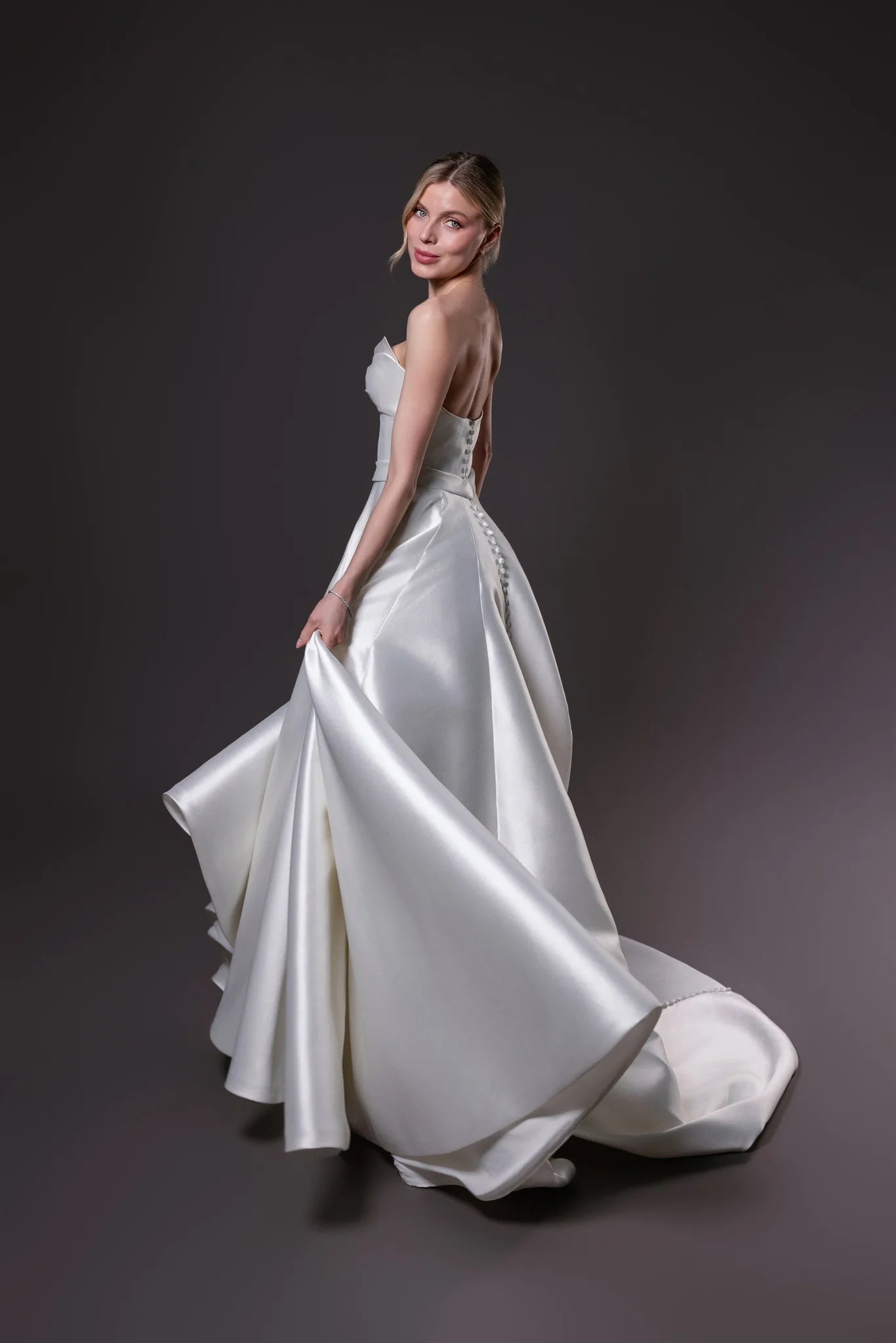 Mirabel silk blend Mikado ball gown with a Basque waistline, bow draped bodice, and full skirt with pockets, Toronto.