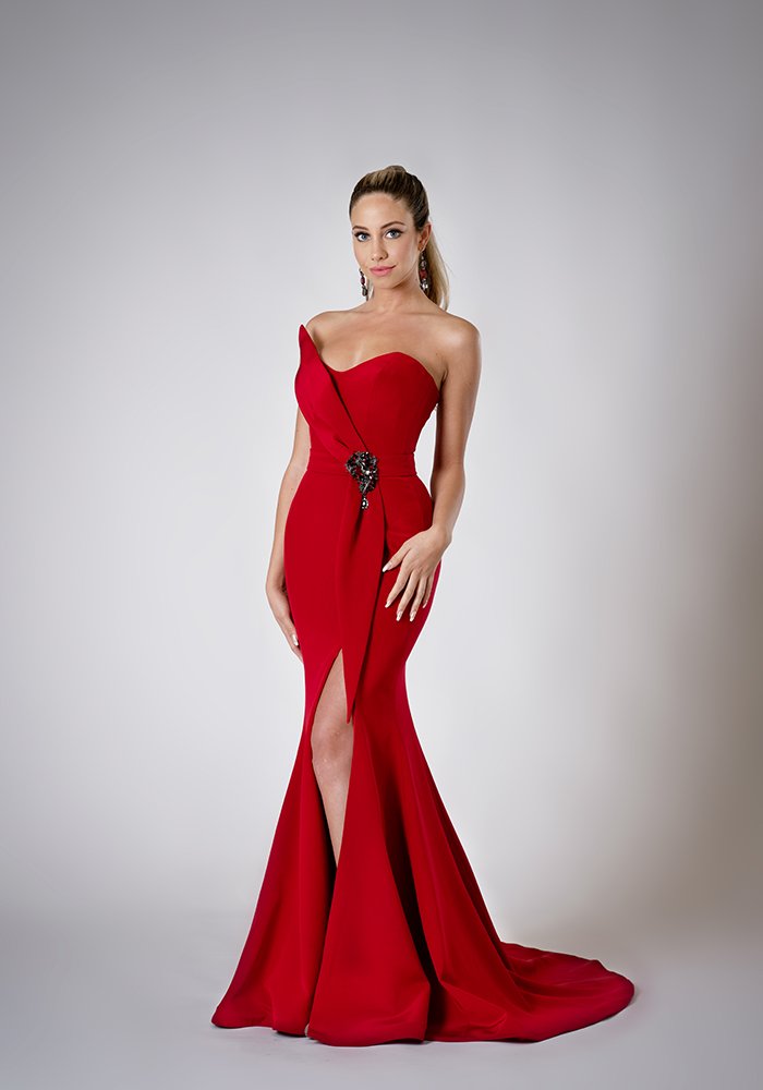 Scarlet silk crepe fit and flare evening gown with a built-in corset, sculpted neckline, crystal brooch, and front slit in Toronto.